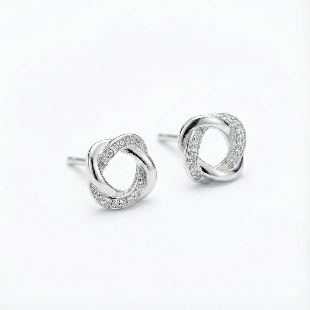 Brincos de prata 925 tipo nó com detalhes de zircônia, fundo branco, joia feminina.